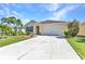 Charming home with a manicured lawn, mature landscaping, and a spacious driveway leading to a two-car garage at 25272 E Lenox Cir, Punta Gorda, FL 33950