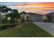 Inviting single-story home featuring a well-manicured lawn, tasteful landscaping, and a warm, neutral color palette at 25272 E Lenox Cir, Punta Gorda, FL 33950