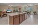 Open kitchen with kitchen island, stainless steel dishwasher and sink looking into the living area at 25272 E Lenox Cir, Punta Gorda, FL 33950