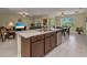 Open kitchen with kitchen island, stainless steel dishwasher and sink looking into the living area at 25272 E Lenox Cir, Punta Gorda, FL 33950