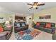 Spacious living room with leather sofas, a colorful rug, and an open layout to the kitchen at 25272 E Lenox Cir, Punta Gorda, FL 33950