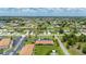 Low-angle aerial view of a single-story home with a parking lot, lawn, and beautiful landscaping at 25275 Rampart Blvd # 404, Punta Gorda, FL 33983