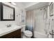 Well-lit bathroom with a shower-tub combo, wood vanity, and large framed mirror at 25275 Rampart Blvd # 404, Punta Gorda, FL 33983