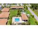 Aerial view showcases the community pool, bocce ball court and lush landscaping at 25275 Rampart Blvd # 404, Punta Gorda, FL 33983