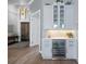Stylish bar area featuring custom cabinets, a wine fridge, and mosaic tile backsplash at 25462 Shore Dr, Punta Gorda, FL 33950