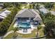 Aerial view of a home with a pool, hot tub, well-manicured lawn, and lush landscaping at 25462 Shore Dr, Punta Gorda, FL 33950