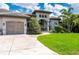 Professionally landscaped yard leads to this home's charming arched entryway and attached garage at 25462 Shore Dr, Punta Gorda, FL 33950