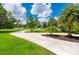 Beautifully landscaped front yard with a long driveway leading to the house at 25462 Shore Dr, Punta Gorda, FL 33950