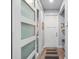 Hallway with modern sliding doors leading to powder room, bench seating, and hardwood floors at 25462 Shore Dr, Punta Gorda, FL 33950
