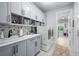 Bright laundry room showcasing gray cabinets, stylish backsplash, and front-load washer/dryer with outside view at 25462 Shore Dr, Punta Gorda, FL 33950
