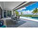 Covered outdoor area featuring a dining set, pool, and beautiful waterfront views at 25462 Shore Dr, Punta Gorda, FL 33950