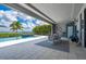 Covered outdoor area featuring a dining set, built-in grill, and access to a pool with bay views at 25462 Shore Dr, Punta Gorda, FL 33950
