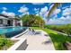 Inviting pool area with lounge chairs, lush landscaping, and serene water views for relaxation at 25462 Shore Dr, Punta Gorda, FL 33950