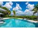 Inviting swimming pool with lounge chairs and a serene water view, perfect for relaxing outdoors at 25462 Shore Dr, Punta Gorda, FL 33950