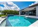 Beautiful backyard pool with an outdoor kitchen, dining area, and lush tropical landscaping at 25462 Shore Dr, Punta Gorda, FL 33950
