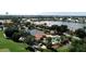 Aerial view of tennis courts, swimming pool, and lake, surrounded by lush landscape and tiled roof buildings at 26254 Stillwater Cir, Punta Gorda, FL 33955