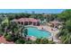 An aerial view of the pool and clubhouse features manicured landscaping and nearby tennis courts, showcasing the community's amenities at 26254 Stillwater Cir, Punta Gorda, FL 33955