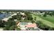 Aerial view of the swimming pool with the community, lake, and a golf course in the background at 26254 Stillwater Cir, Punta Gorda, FL 33955