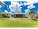 Expansive backyard with well-manicured lawn, lush landscaping, and screened lanai, perfect for outdoor living and entertaining at 26254 Stillwater Cir, Punta Gorda, FL 33955