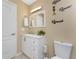 Well-lit bathroom featuring a vanity with white cabinets, toilet, and light fixture at 26254 Stillwater Cir, Punta Gorda, FL 33955