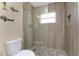 Modern shower with glass door and wood-look tile surround, featuring a pebble floor at 26254 Stillwater Cir, Punta Gorda, FL 33955