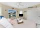 Cozy bedroom with neutral tones, large window, ceiling fan, and coastal-themed décor at 26254 Stillwater Cir, Punta Gorda, FL 33955