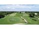 Expansive golf course view with lush greenery and mature trees under a partly cloudy sky, offering a serene landscape at 26254 Stillwater Cir, Punta Gorda, FL 33955