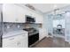 Bright kitchen with white cabinets, stainless steel appliances, and view to the office at 26254 Stillwater Cir, Punta Gorda, FL 33955