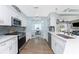 Well-equipped kitchen with white cabinets, stainless steel appliances, and a sliding door to the office at 26254 Stillwater Cir, Punta Gorda, FL 33955