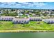 Aerial view of townhomes in a lakeside community with meticulously landscaped lawns and mature trees at 26310 Rampart Blvd # 504, Punta Gorda, FL 33983