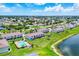 Aerial view of townhome community with pool near a lake, surrounded by lush greenery at 26310 Rampart Blvd # 504, Punta Gorda, FL 33983