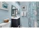 Bathroom with a blue-themed coastal decor featuring framed art and patterned shower curtain at 26310 Rampart Blvd # 504, Punta Gorda, FL 33983