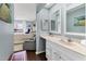Bathroom with double mirrors and access to bedroom seating area overlooking the water at 26310 Rampart Blvd # 504, Punta Gorda, FL 33983
