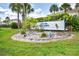 Community entrance to Lake Rio Town Homes with well-maintained landscaping and visible community sign at 26310 Rampart Blvd # 504, Punta Gorda, FL 33983