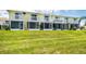 Charming two-story townhome featuring screened lanai and white railing balcony overlooking a well-manicured lawn at 26310 Rampart Blvd # 504, Punta Gorda, FL 33983