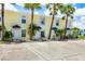 Close-up of condo units with palm trees, assigned parking, and well-lit walkways at 26310 Rampart Blvd # 504, Punta Gorda, FL 33983