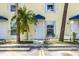 Close-up view of a condo entrance, featuring a white door, bright window, and tropical landscaping at 26310 Rampart Blvd # 504, Punta Gorda, FL 33983