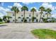 Condo building showcasing tropical landscaping, assigned parking, and a welcoming entrance at 26310 Rampart Blvd # 504, Punta Gorda, FL 33983