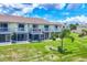 Charming two-story townhome featuring screened lanai and white railing balcony overlooking a well-manicured lawn at 26310 Rampart Blvd # 504, Punta Gorda, FL 33983