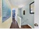 Bright hallway with wood floors and colorful artwork leading to other rooms at 26310 Rampart Blvd # 504, Punta Gorda, FL 33983
