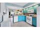 Open kitchen with bright cabinetry, modern appliances, and a breakfast bar overlooking the living room at 26310 Rampart Blvd # 504, Punta Gorda, FL 33983