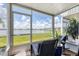 Screened-in porch with lake view, seating, and plants at 26310 Rampart Blvd # 504, Punta Gorda, FL 33983