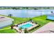 Aerial view of a community pool next to the lake with ample seating and shade at 26310 Rampart Blvd # 504, Punta Gorda, FL 33983