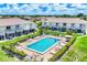 Community pool with lounge chairs surrounded by manicured shrubbery and palm trees near lakeside homes at 26310 Rampart Blvd # 504, Punta Gorda, FL 33983