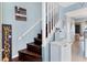 Stylish staircase featuring dark wood steps, white railing, and welcome decor at 26310 Rampart Blvd # 504, Punta Gorda, FL 33983