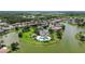 An aerial view shows a community with a pool surrounded by lush landscaping and waterways at 2736 Suncoast Lakes Blvd, Punta Gorda, FL 33980