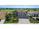 Aerial view of a charming two-story home featuring a three-car garage and well-maintained landscaping at 2736 Suncoast Lakes Blvd, Punta Gorda, FL 33980