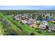 An aerial view captures homes surrounding a serene lake, combining lush greenery with residential appeal at 2736 Suncoast Lakes Blvd, Punta Gorda, FL 33980
