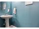 Powder room with pedestal sink, modern faucet, and turquoise painted walls at 2736 Suncoast Lakes Blvd, Punta Gorda, FL 33980