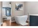 A freestanding tub is the highlight of this bathroom attached to the main bedroom with hardwood floors at 2736 Suncoast Lakes Blvd, Punta Gorda, FL 33980